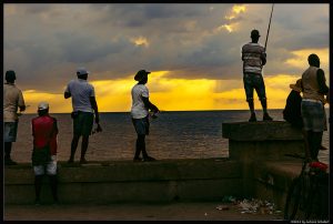 Hombres pescando al atardecer en el Malecón de la Habana.